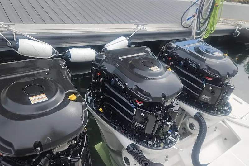  Yacht Photos Pics Triple outboard engines on a 2023 Regal 38 FXO boat docked at a marina.