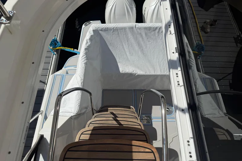  Yacht Photos Pics 2023 Regal 38 FXO boat with covered seating and wooden steps, docked at marina.