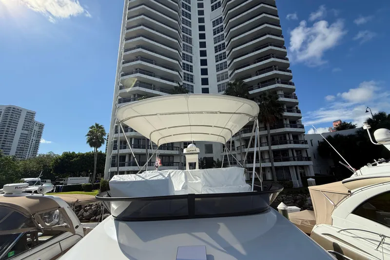  Yacht Photos Pics 2023 Regal 38 FXO yacht docked near tall buildings under a clear blue sky.