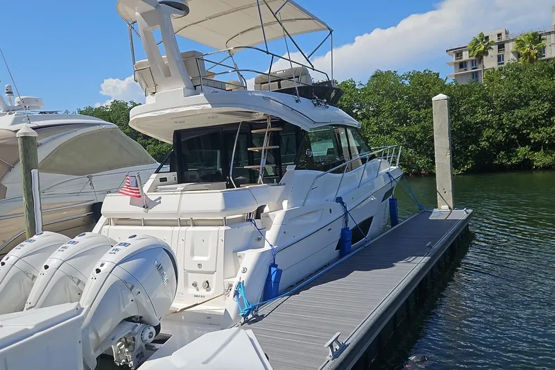  Yacht Photos Pics 2023 Regal 38 FXO yacht docked, featuring triple outboard engines and a spacious upper deck.