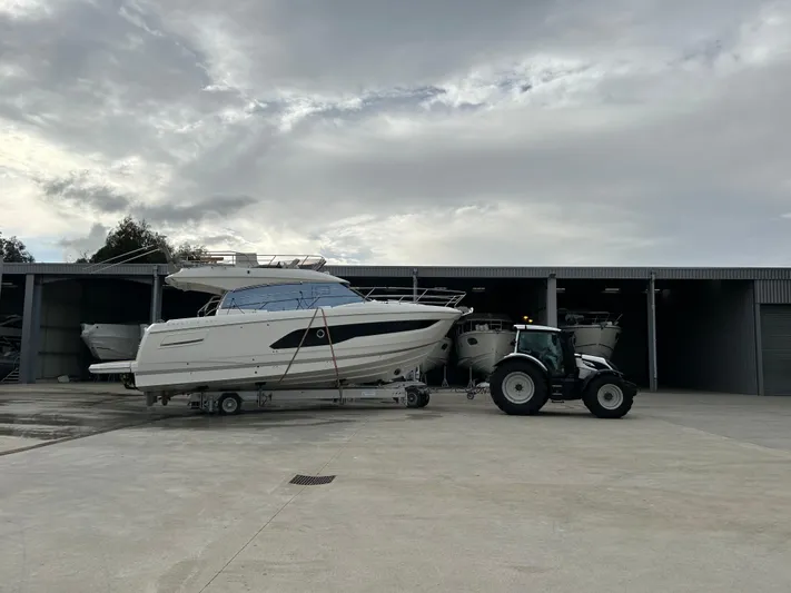 420 Fly Yacht Photos Pics 2024 Prestige 420 Fly yacht being towed by a tractor outside a storage facility.