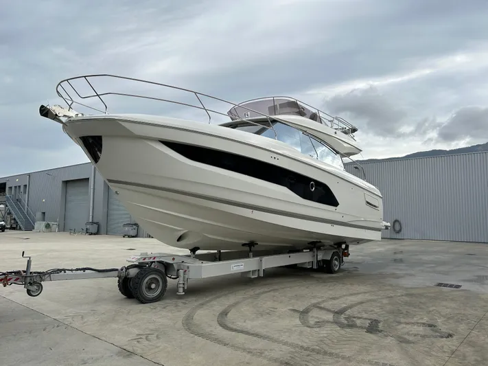 420 Fly Yacht Photos Pics 2024 Prestige 420 Fly yacht on trailer, parked outdoors near industrial buildings.