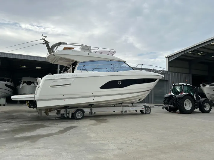 420 Fly Yacht Photos Pics 2024 Prestige 420 Fly yacht on trailer near warehouse and tractor.