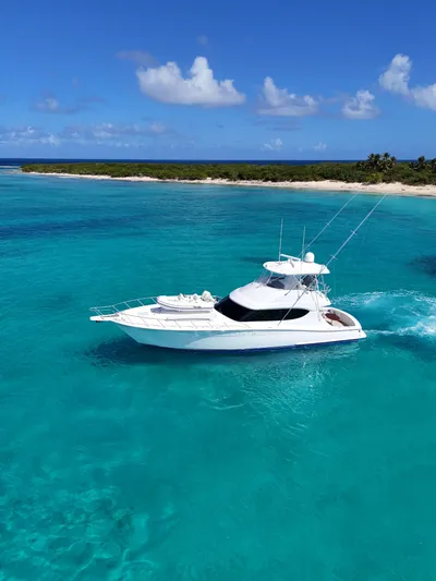  Yacht Photos Pics 2011 Hatteras GT60 yacht cruising in clear turquoise waters near a tropical island.