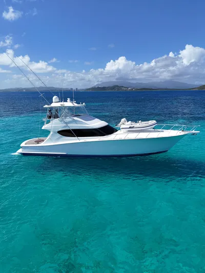  Yacht Photos Pics 2011 Hatteras GT60 yacht on clear turquoise water under a bright blue sky.