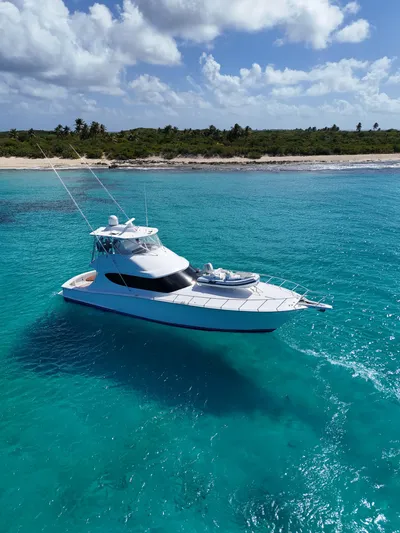  Yacht Photos Pics 2011 Hatteras GT60 yacht cruising in clear turquoise waters near a tropical shoreline.