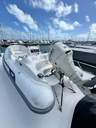  Yacht Photos Pics 2011 Hatteras GT60 yacht with a small inflatable boat and outboard motor, docked in a marina.