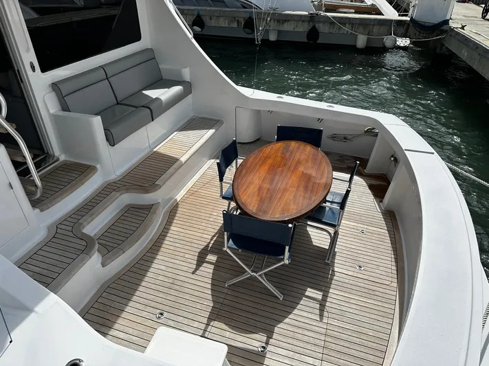  Yacht Photos Pics 2011 Hatteras GT60 yacht deck with seating and wooden table, docked at marina.