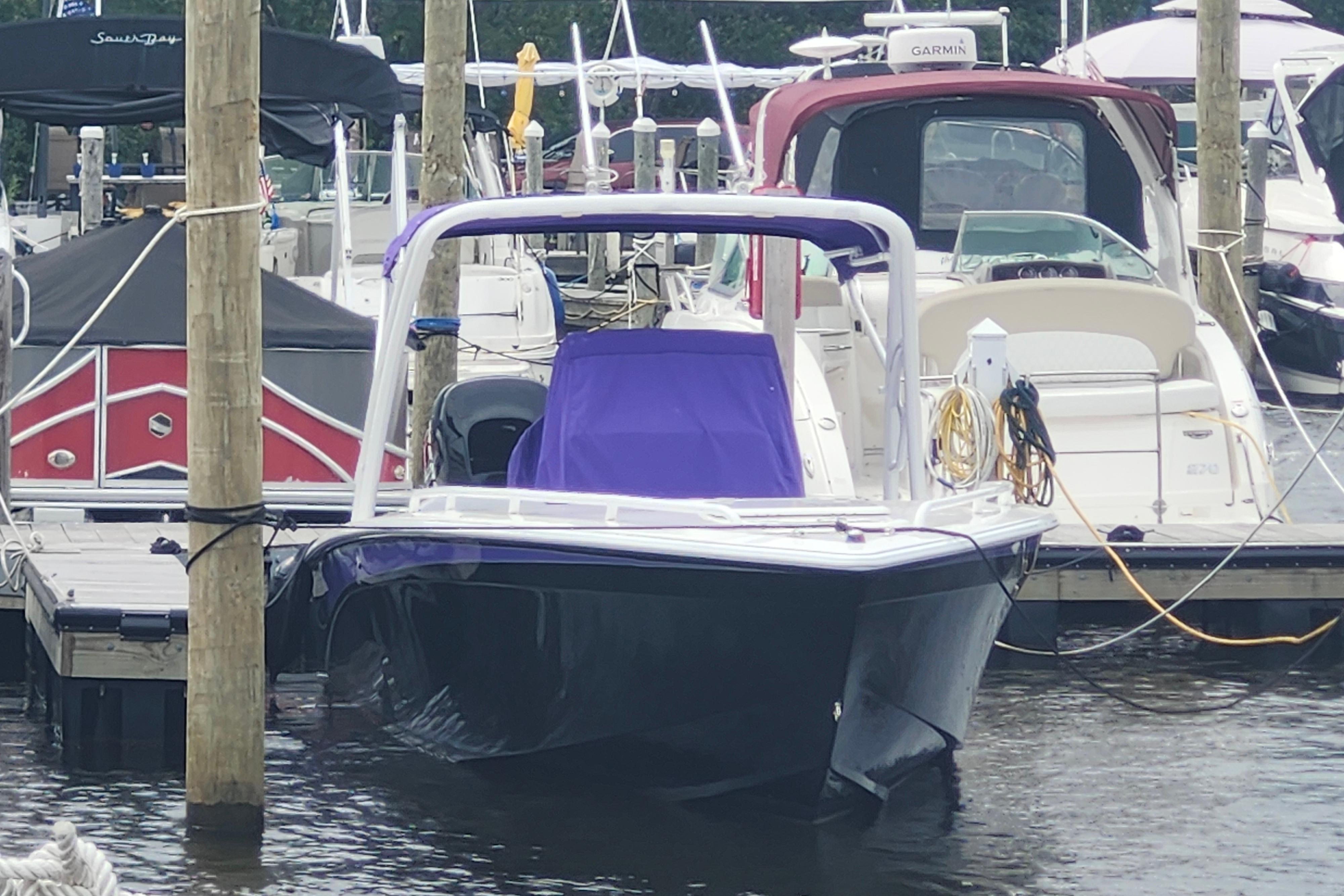 2014 Concept 30 Cuddy boat docked at marina, surrounded by other vessels.