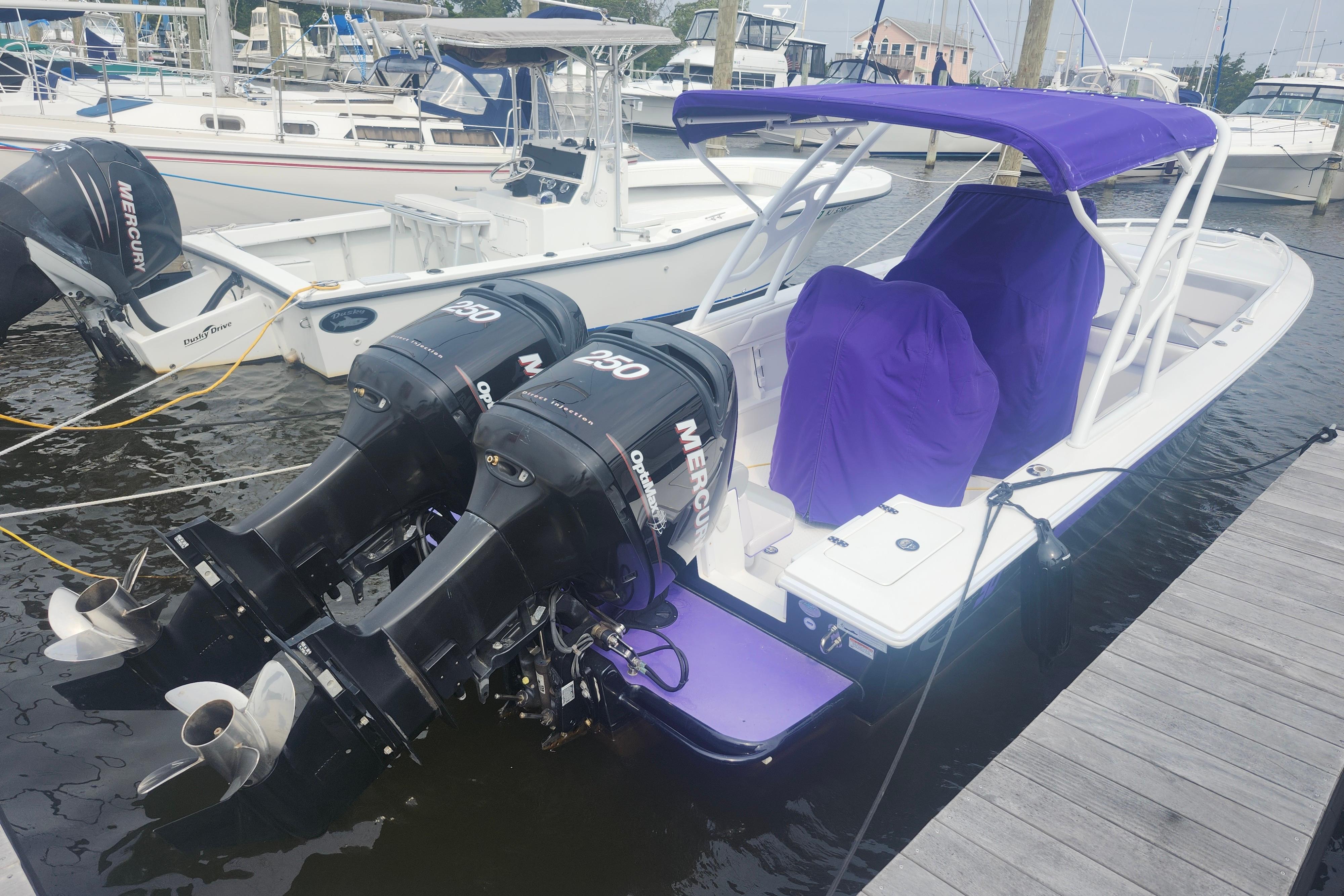 2014 Concept 30 Cuddy boat with twin Mercury engines docked at marina.