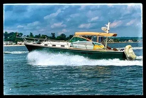  Yacht Photos Pics Sabreline 36 Express 1999 cruising on water with scenic background.