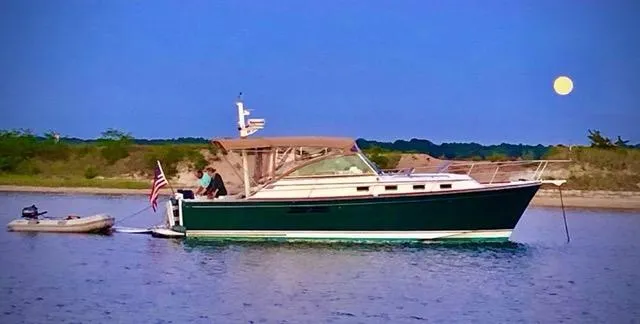  Yacht Photos Pics Sabreline 36 Express 1999 boat on calm water at sunset with full moon.