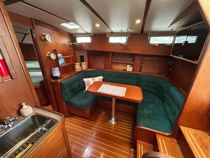  Yacht Photos Pics Cozy interior of 1999 Sabreline 36 Express yacht with green seating and wooden finishes.