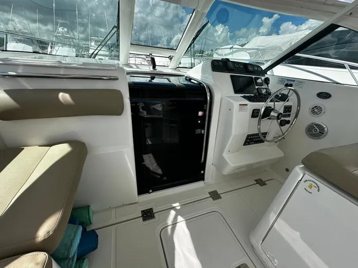  Yacht Photos Pics 2005 Tiara Yachts 3200 Open cockpit with steering wheel and seating under a sunny sky.