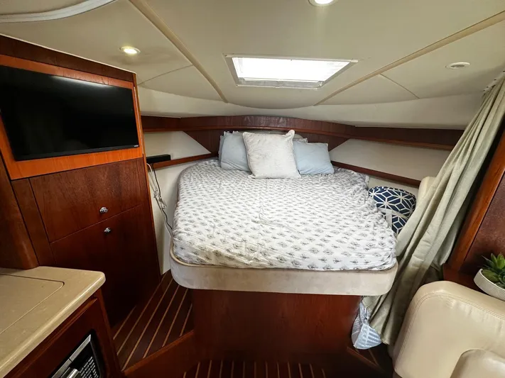  Yacht Photos Pics Luxurious cabin interior of 2005 Tiara Yachts 3200 Open with cozy bed and TV.