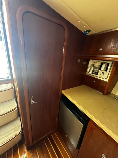  Yacht Photos Pics 2005 Tiara Yachts 3200 Open interior with kitchenette and wooden cabinetry.