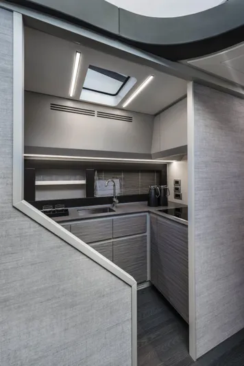 Our Trade Yacht Photos Pics Modern kitchen interior of 2023 Pershing 6X yacht with sleek design and skylight.