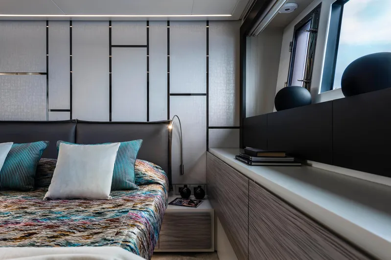 Our Trade Yacht Photos Pics Luxurious bedroom interior of 2023 Pershing 6X yacht with modern decor and stylish bedding.