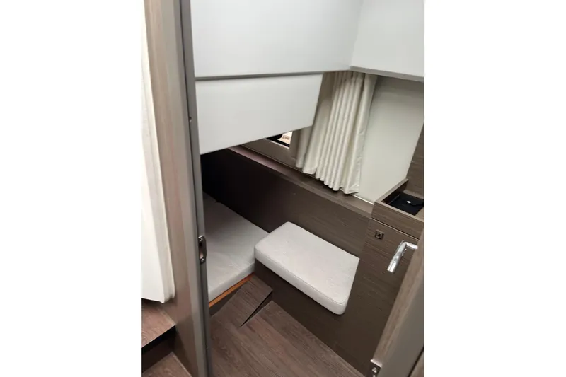 Yacht Photos Pics 2025 Jeanneau NC 895 Sport Series 2 cabin interior with bed and curtains.