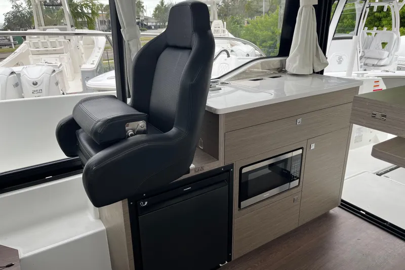  Yacht Photos Pics Interior of 2025 Jeanneau NC 895 Sport Series 2 with helm seat and kitchenette.