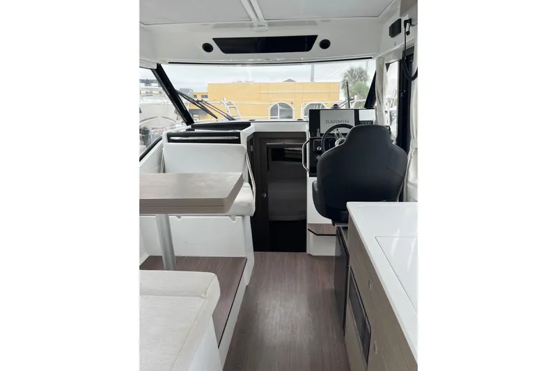  Yacht Photos Pics Interior of 2025 Jeanneau NC 895 Sport Series 2 boat, featuring helm and seating area.