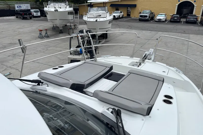  Yacht Photos Pics 2025 Jeanneau NC 895 Sport Series 2 boat with sun pads, docked in a marina.