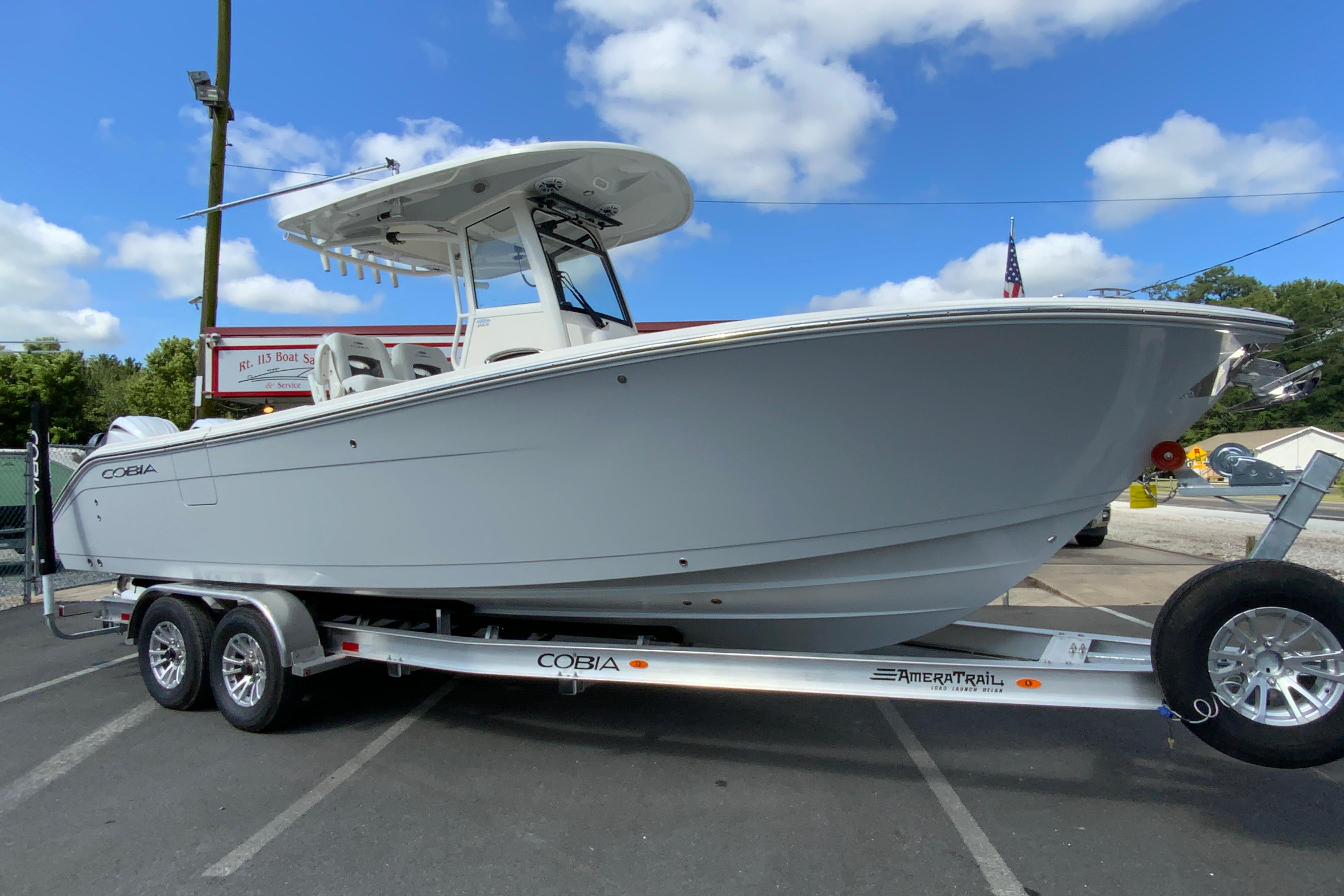 2026 Cobia 265 Open Center Console boat on trailer, parked outdoors.