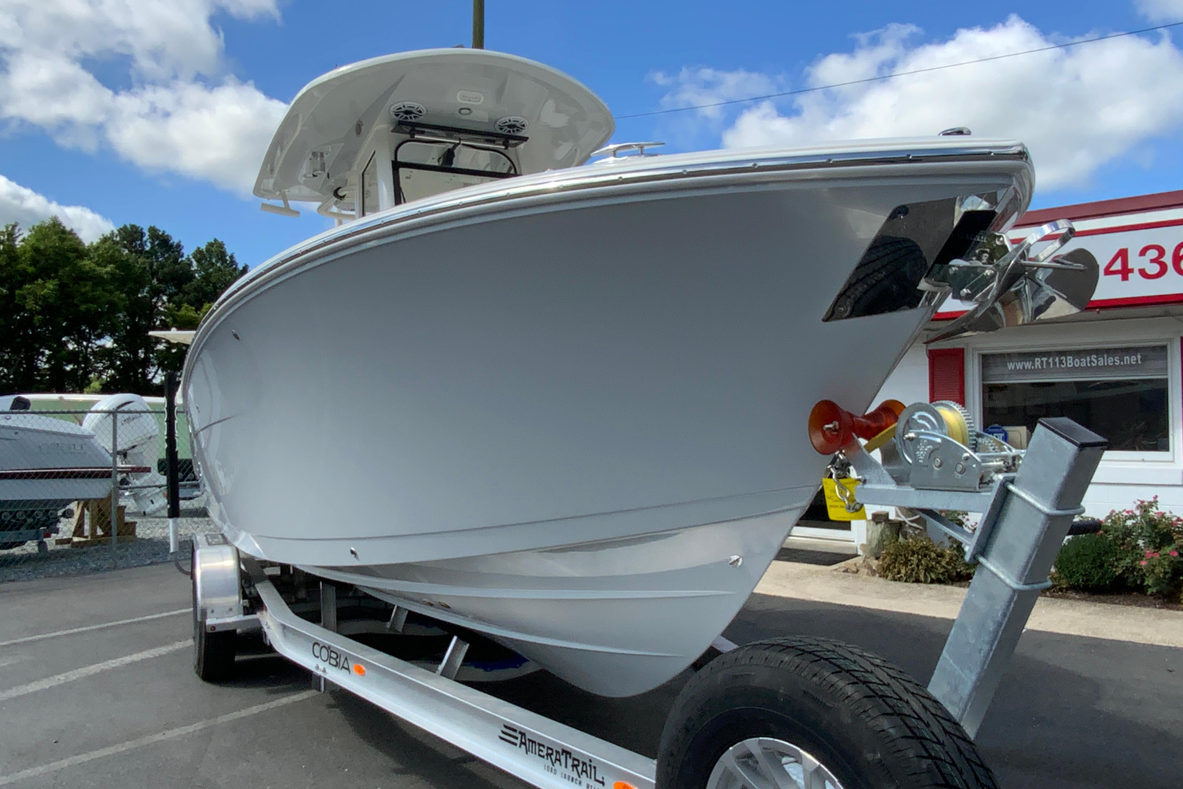 2026 Cobia 265 Open Center Console boat on trailer, parked outdoors.