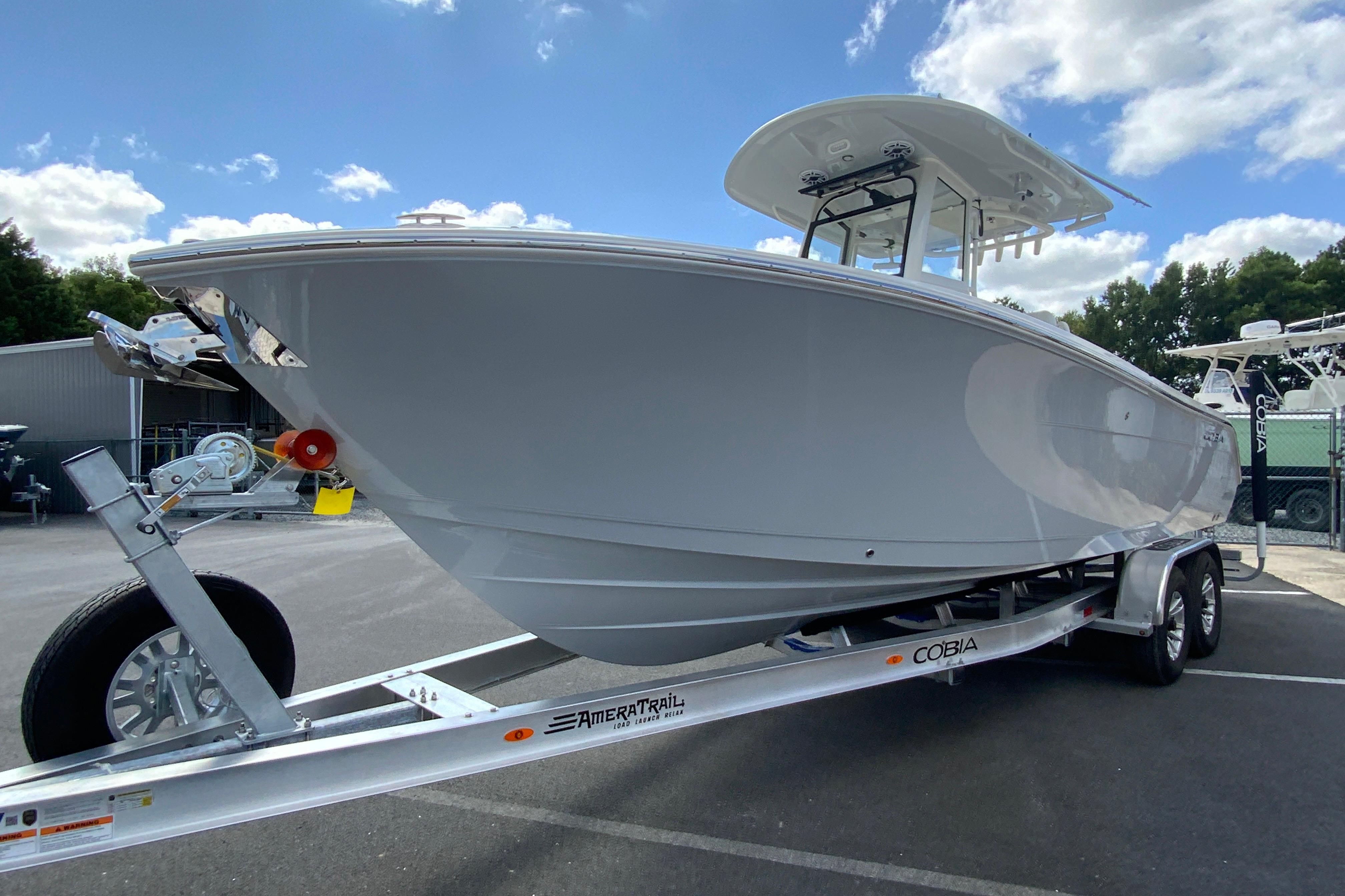 2026 Cobia 265 Open Center Console boat on trailer under blue sky.