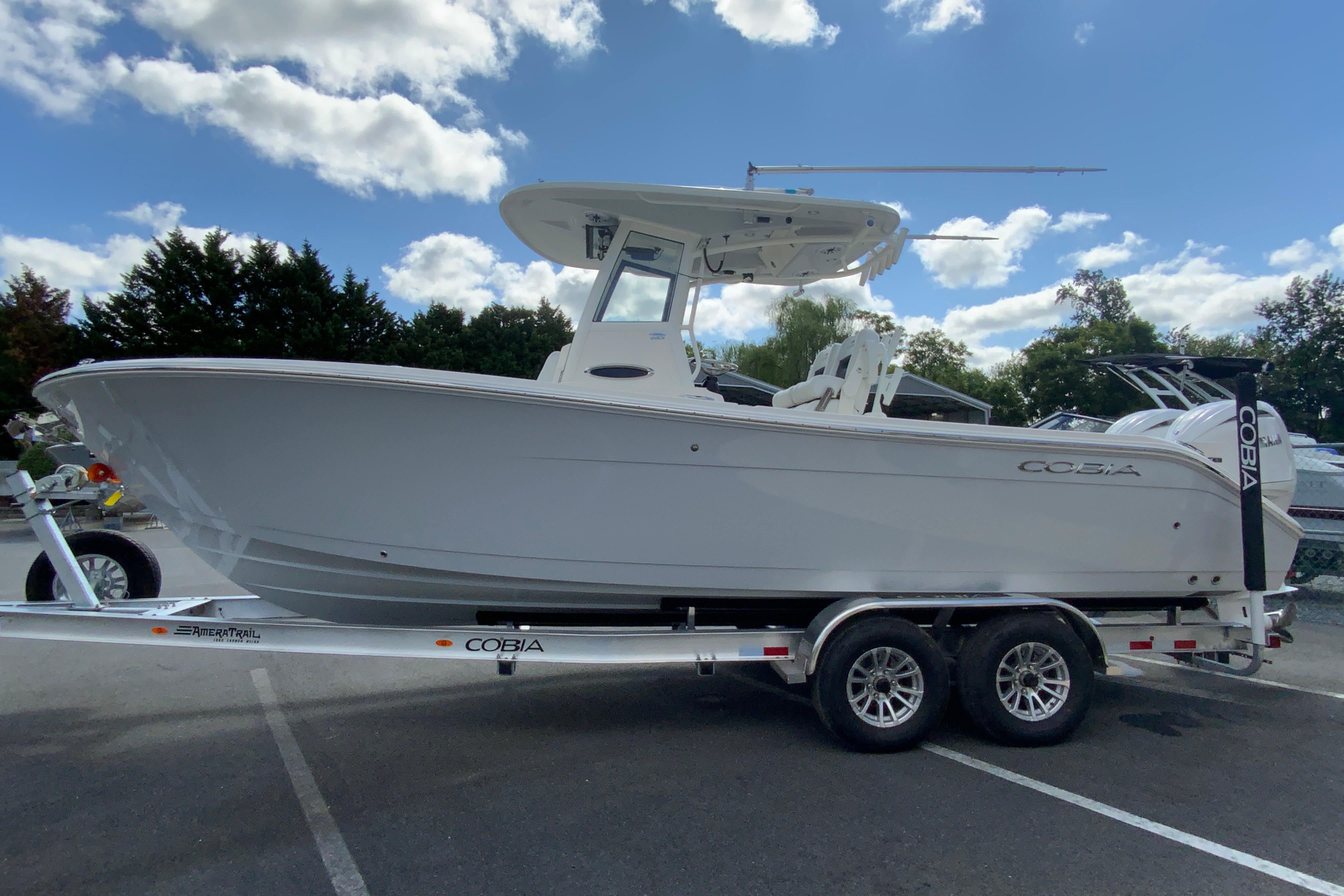 2026 Cobia 265 Open Center Console boat on trailer under blue sky.