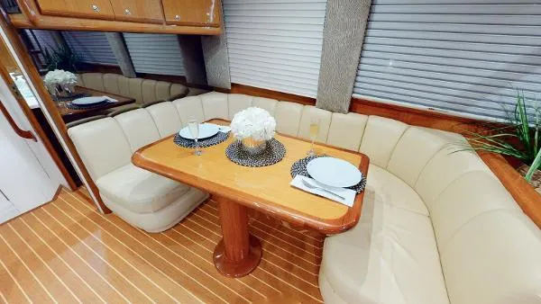 Reel Blonde Yacht Photos Pics 1999 Viking 72 Sport Fish yacht interior dining area with elegant table setting and plush seating.