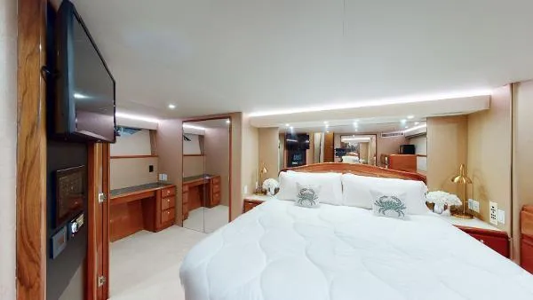 Reel Blonde Yacht Photos Pics Luxurious bedroom interior of a 1999 Viking 72 Sport Fish yacht with modern amenities.
