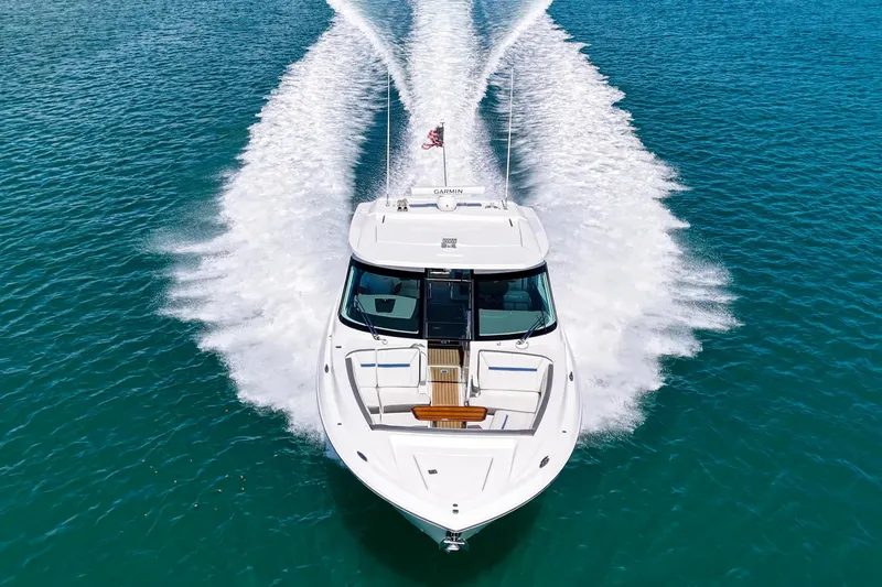 Knot Sorry Yacht Photos Pics 2022 Tiara Yachts 38 LX cruising on clear blue water, aerial view.