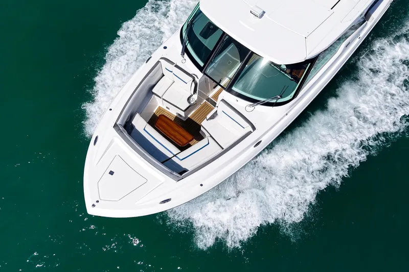 Knot Sorry Yacht Photos Pics 2022 Tiara Yachts 38 LX cruising on clear blue water, aerial view.