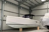2019 Fjord 36' Open boat in storage, elevated on blocks, with a metal ladder nearby.