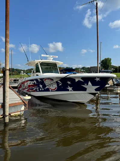 Triple Play Yacht Photos Pics 2015 Boston Whaler 370 Outrage with patriotic design docked on a sunny day.