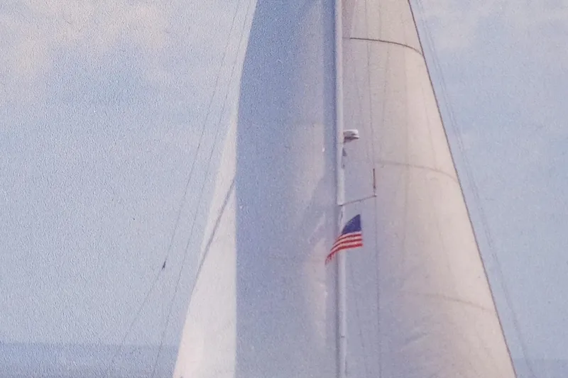 Genka Yacht Photos Pics 2017 Beneteau Sense 50 sailboat with American flag, sailing under clear skies.