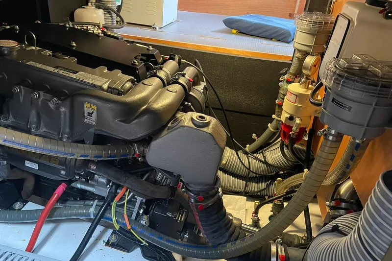 Genka Yacht Photos Pics Engine room of a 2017 Beneteau Sense 50 yacht, showcasing complex machinery and hoses.