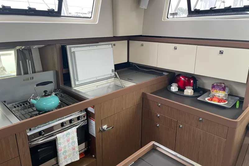 Genka Yacht Photos Pics Modern kitchen in a 2017 Beneteau Sense 50 yacht with stove, cabinets, and countertop appliances.