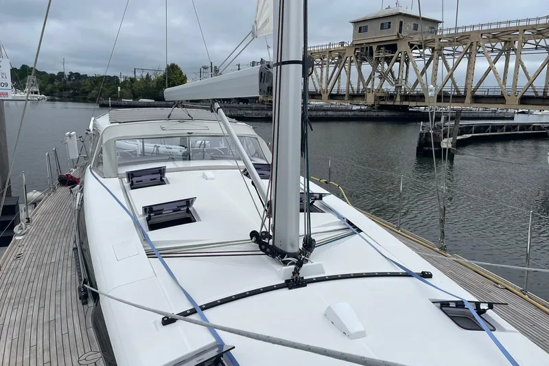 Genka Yacht Photos Pics 2017 Beneteau Sense 50 yacht docked near a bridge on a cloudy day.