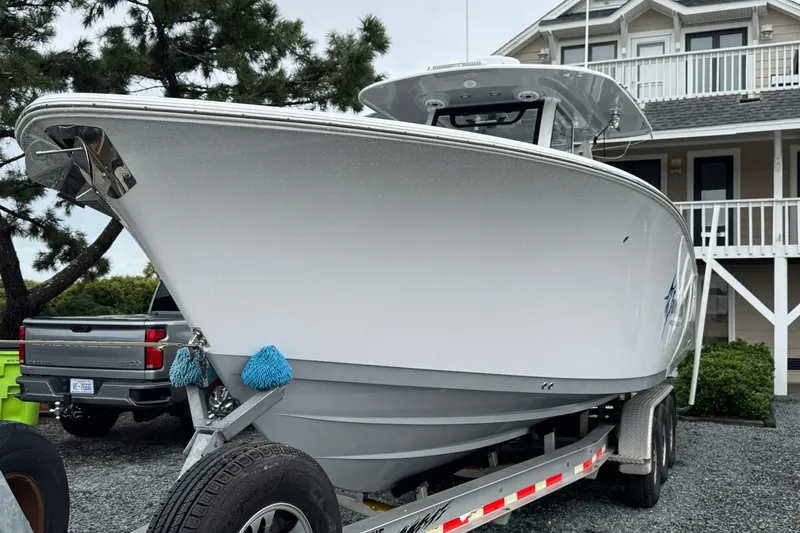  Yacht Photos Pics 2021 Sportsman Open 322 Center Console boat on trailer near house.