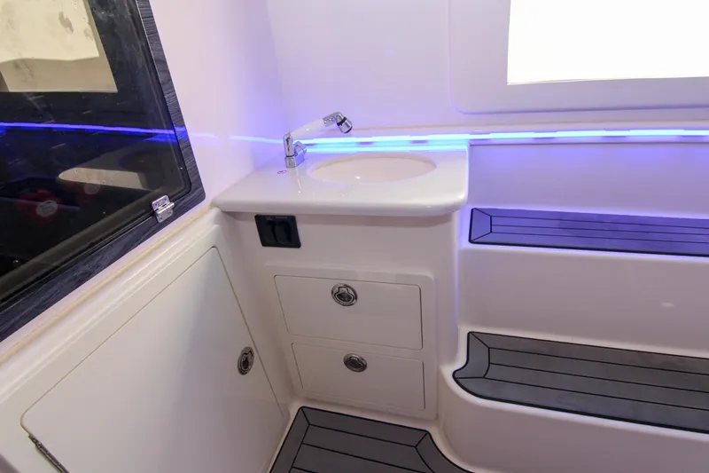  Yacht Photos Pics 2022 Cobia 350 Center Console interior with sink, storage, and blue LED lighting.