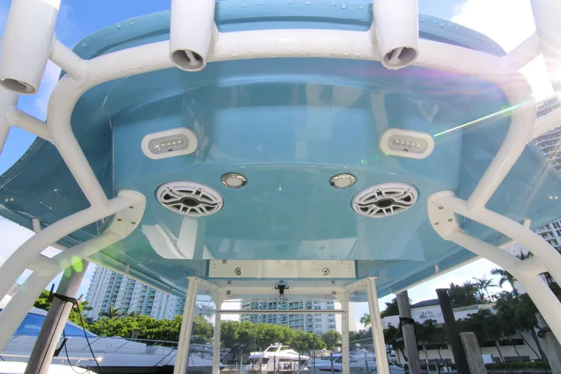  Yacht Photos Pics 2022 Cobia 350 Center Console boat with blue T-top and speakers, docked in marina.