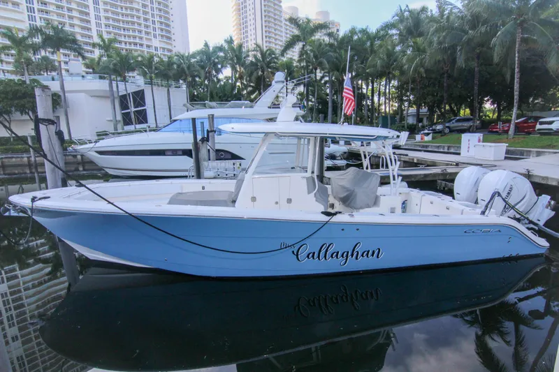  Yacht Photos Pics 2022 Cobia 350 Center Console boat docked in a marina with palm trees.