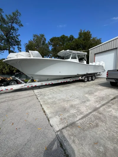  Yacht Photos Pics 2024 Onslow Bay 41 boat on trailer, parked outdoors near a garage.