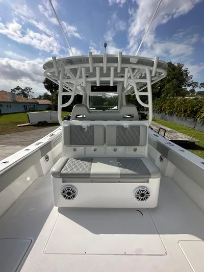  Yacht Photos Pics 2024 Onslow Bay 41 boat interior with cushioned seating and rod holders under a blue sky.
