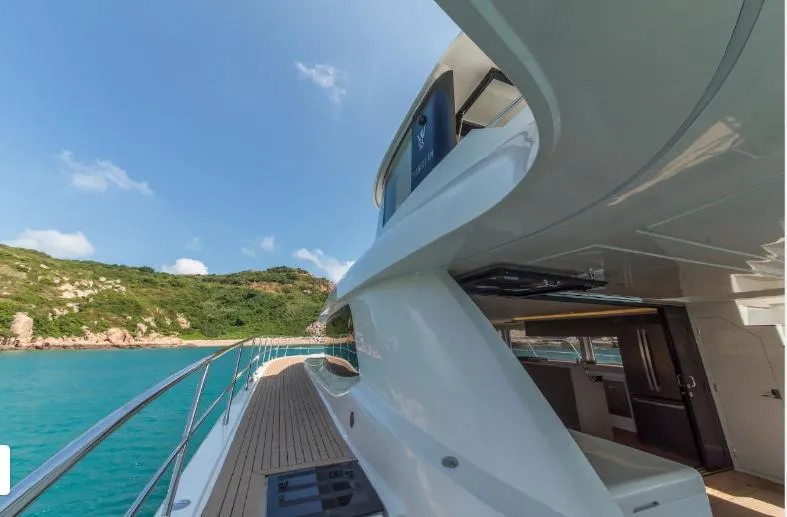 Bikini Sunset Yacht Photos Pics Granocean 57 Yacht, 2023, on turquoise water near green coastline.