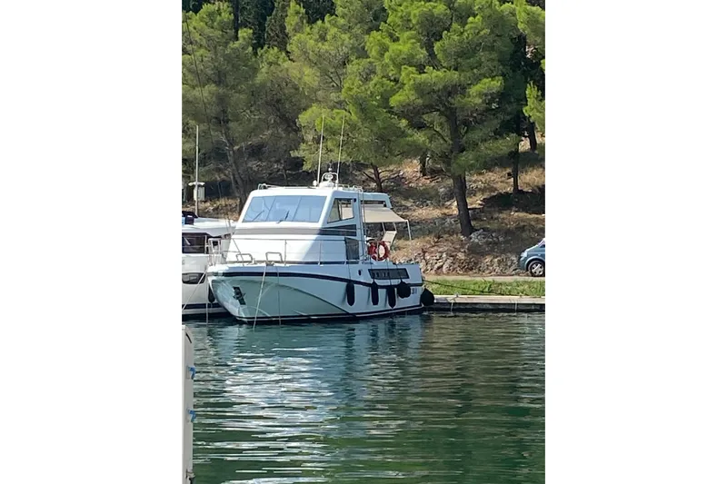 Captain Back Yacht Photos Pics 1988 Cantiere Navale di Pesaro Studio Mare Atmosfere 46 yacht docked by trees.