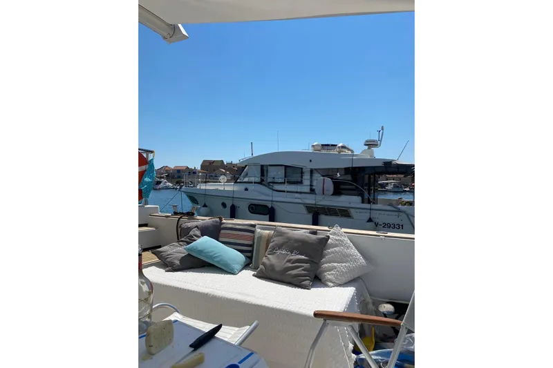 Captain Back Yacht Photos Pics Cozy yacht deck with cushions, overlooking a 1988 Studio Mare Atmosfere 46 boat in a sunny marina.