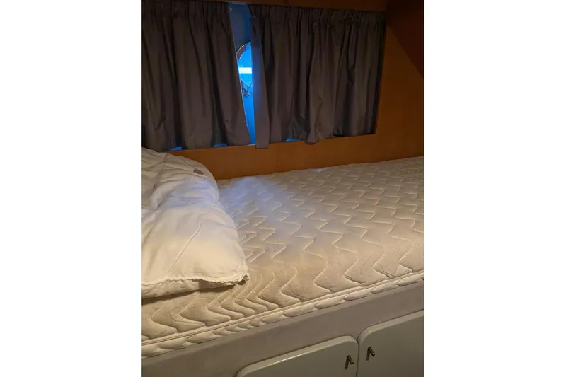 Captain Back Yacht Photos Pics Interior cabin of 1988 Studio Mare Atmosfere 46 yacht with bed and curtains.